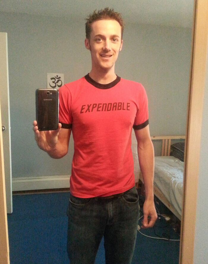 Man taking mirror selfie wearing red expendable t-shirt, representing employees who walked out with jokes and pranks.