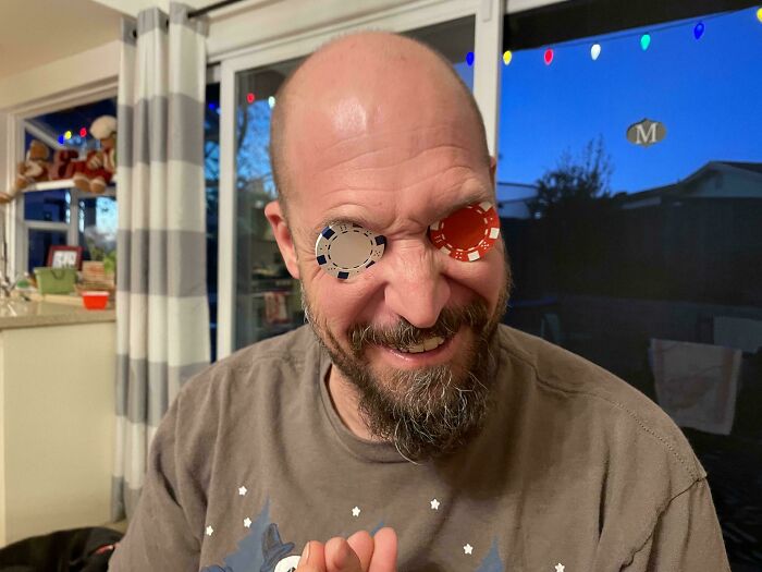 Man playing with poker chips covering his eyes, showing playful and wholesome moments that prove men never grow up.