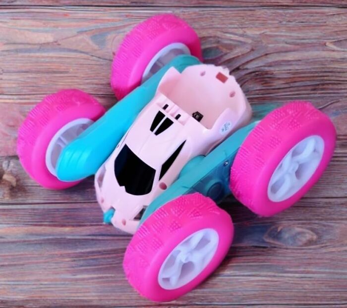 Toy car with large pink wheels on wooden surface, featured in Black Friday week deals on kids toys for Christmas.