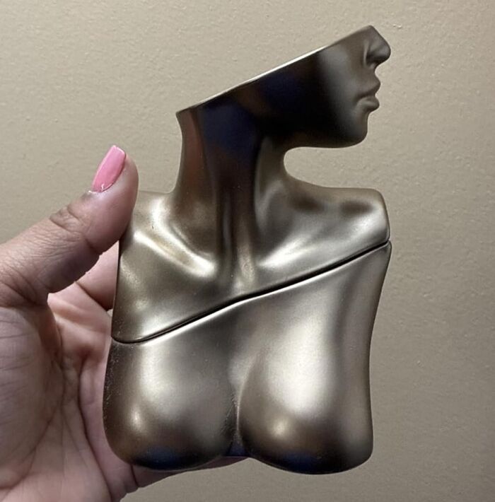 Hand holding a bronze decorative sculpture of a female torso and head, a unique Black Friday stocking stuffer idea.