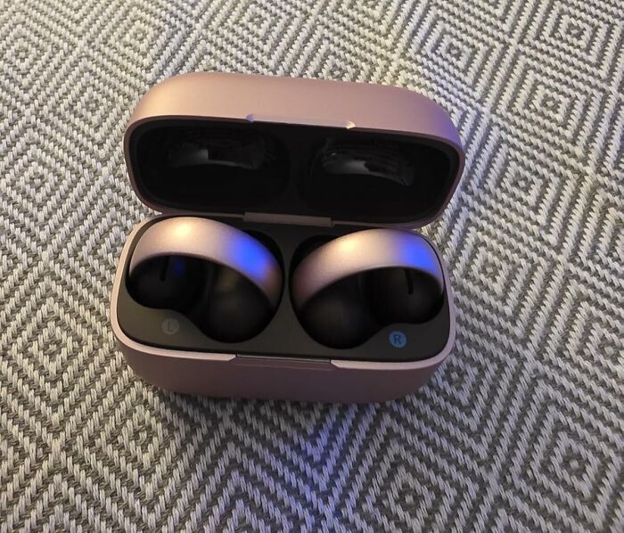 Wireless earbuds in a charging case on a textured surface, a popular Black Friday deal for stocking stuffers.
