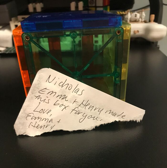 Handwritten note beside colorful magnetic building blocks, showing sibling gratitude and appreciation.