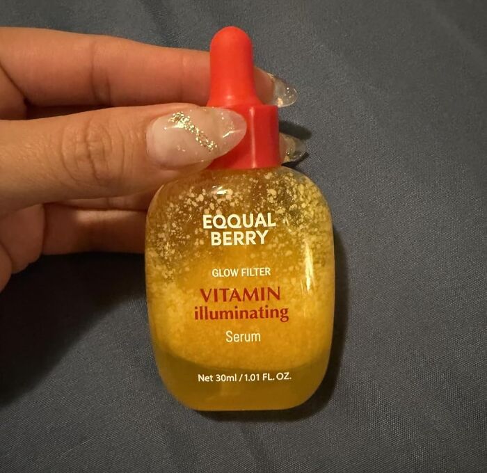 Hand holding a dropper bottle of vitamin illuminating serum, a popular Black Friday deal on stocking stuffers.