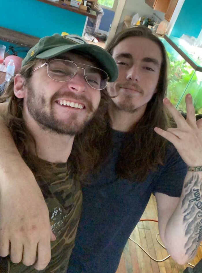 Two brothers smiling and posing closely together inside a colorful room showing sibling gratitude and bond.
