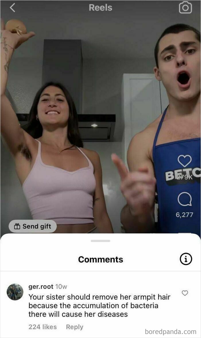 Two people in a kitchen with a woman showing armpit hair, highlighting cringe-worthy takes on women in social media comments.