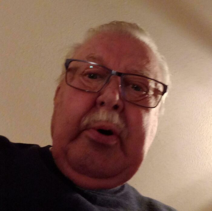 Older man wearing glasses looking directly at the camera in a wholesome photo showing men never grow up.