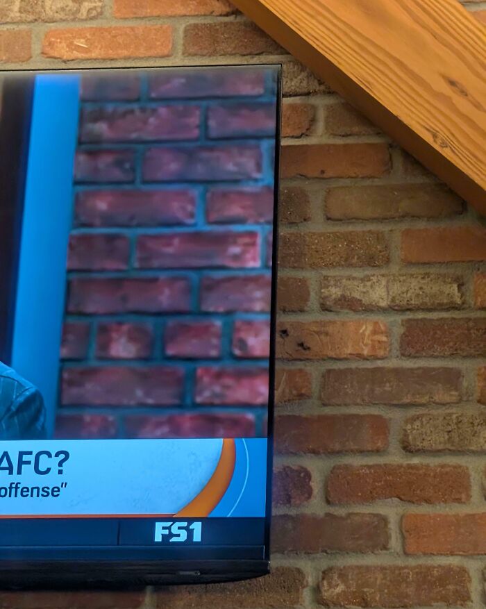 Close-up of a TV screen perfectly aligned with a brick wall, showcasing a moment that scratched everyone’s brain just right.