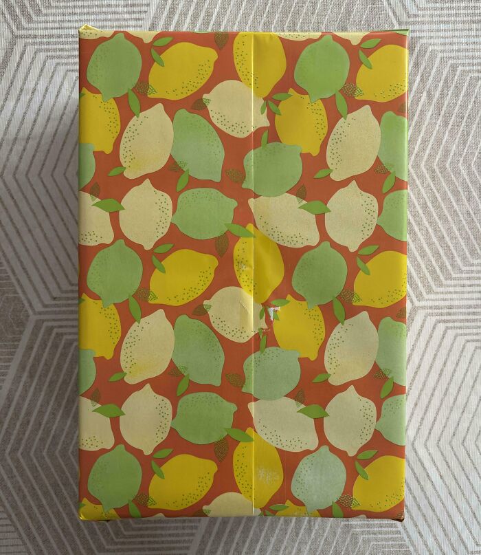 Wrapping paper with perfectly aligned lemons and leaves pattern creating a visually satisfying design.