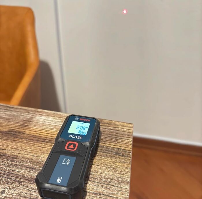 Laser measuring tool on wooden table showing distance measurement, highlighting Cyber Monday biggest steals deals.