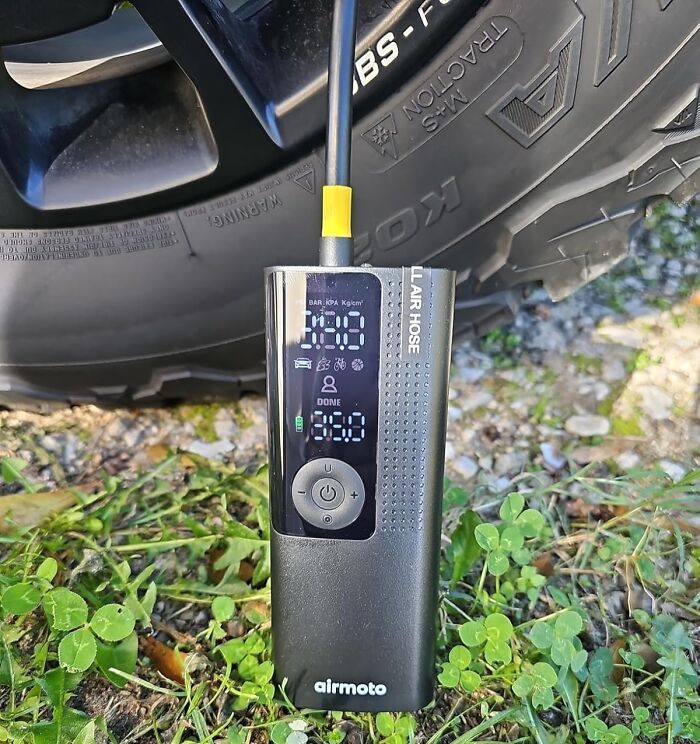 Portable digital tire inflator in use on a tire outdoors, highlighting Cyber Monday biggest steals deals.
