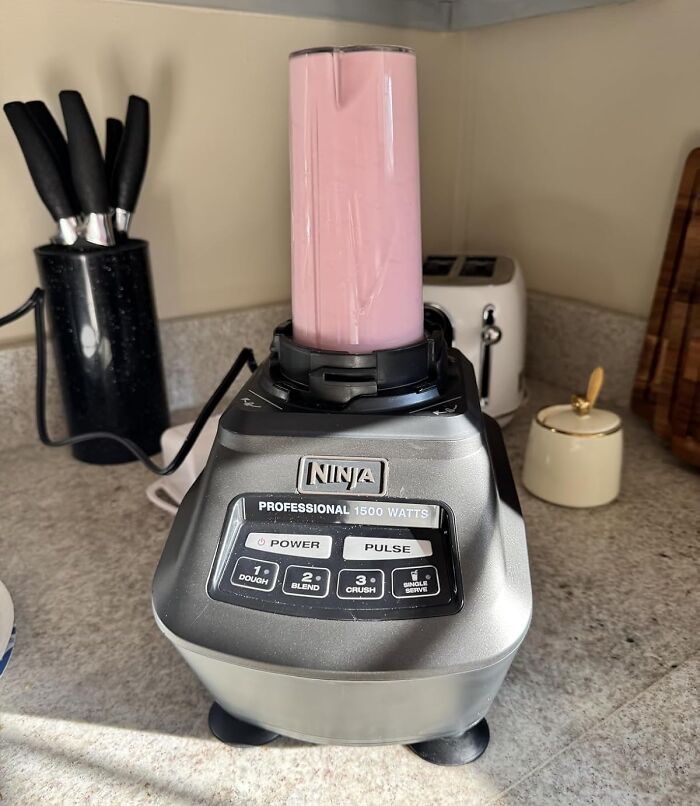 Ninja blender with a pink smoothie on a kitchen counter highlighting Black Friday deals for procrastinators.