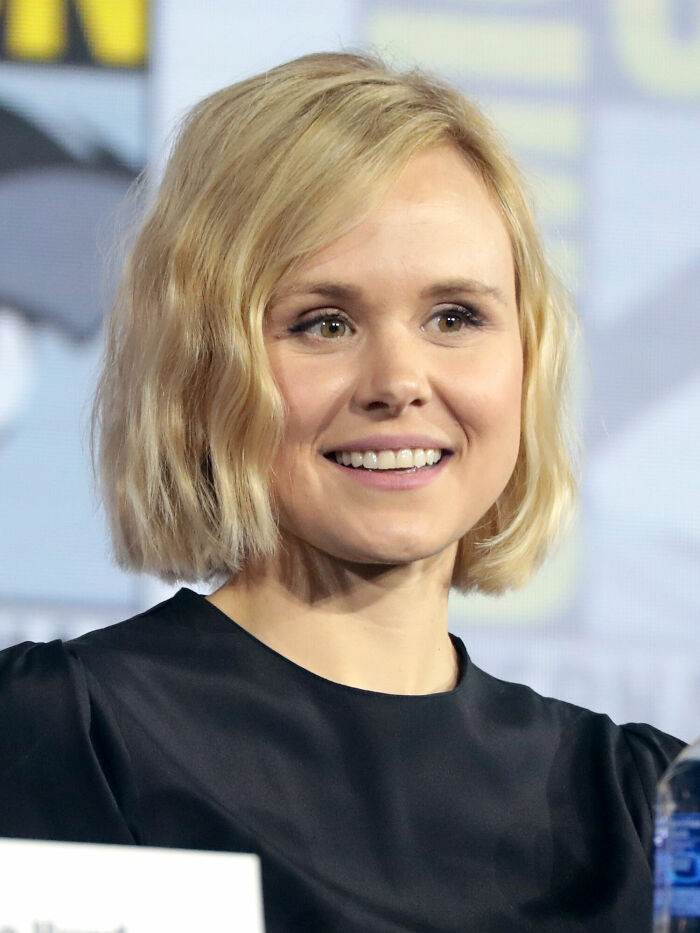 Alison Pill smiling at an event, wearing a black top with blonde hair in a short wavy style, highlighting her career.