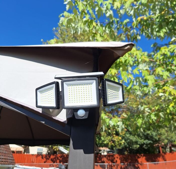 Outdoor LED security light mounted on a pole with motion sensor under a canopy during bright sunny day Cyber Monday deals