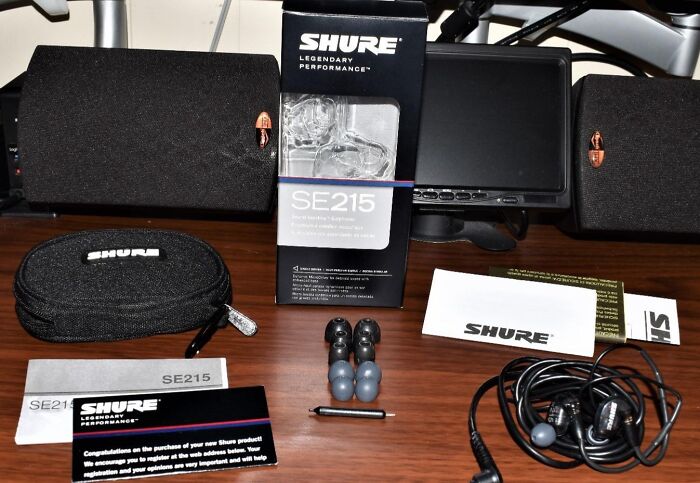 Shure SE215 earphones and accessories laid out on a table highlighting top Cyber Monday tech deals.