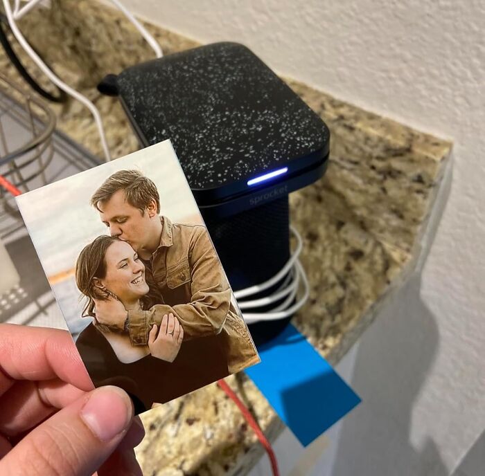 Photo printer on granite countertop printing a photo, illustrating Cyber Monday tech deals for portable tech gadgets.