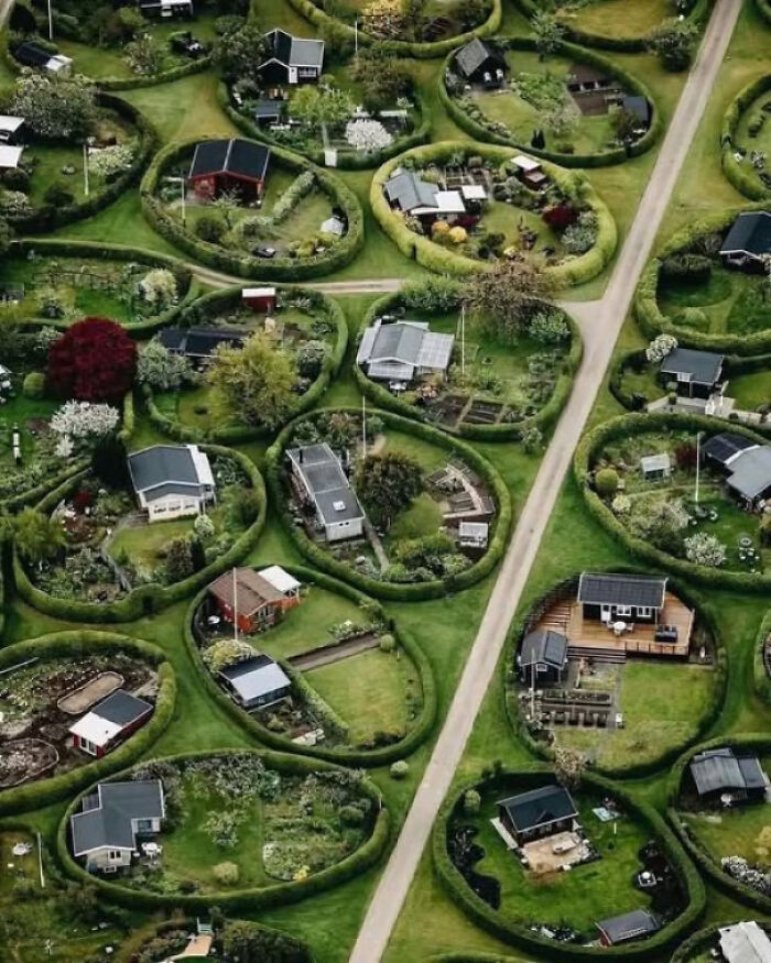 Aerial view of uniquely shaped garden plots with small houses, showcasing patterns of existence and reality in nature.