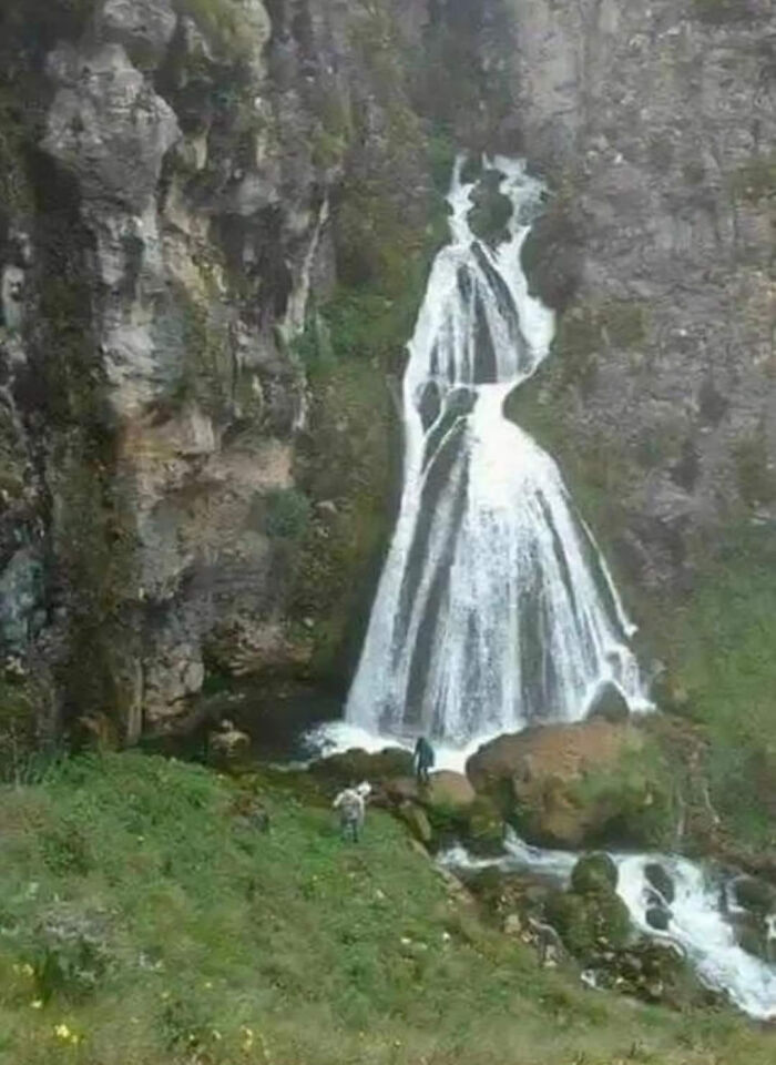 Waterfall shaped like a couple embracing in nature, symbolizing existence and reality within the universe theme.