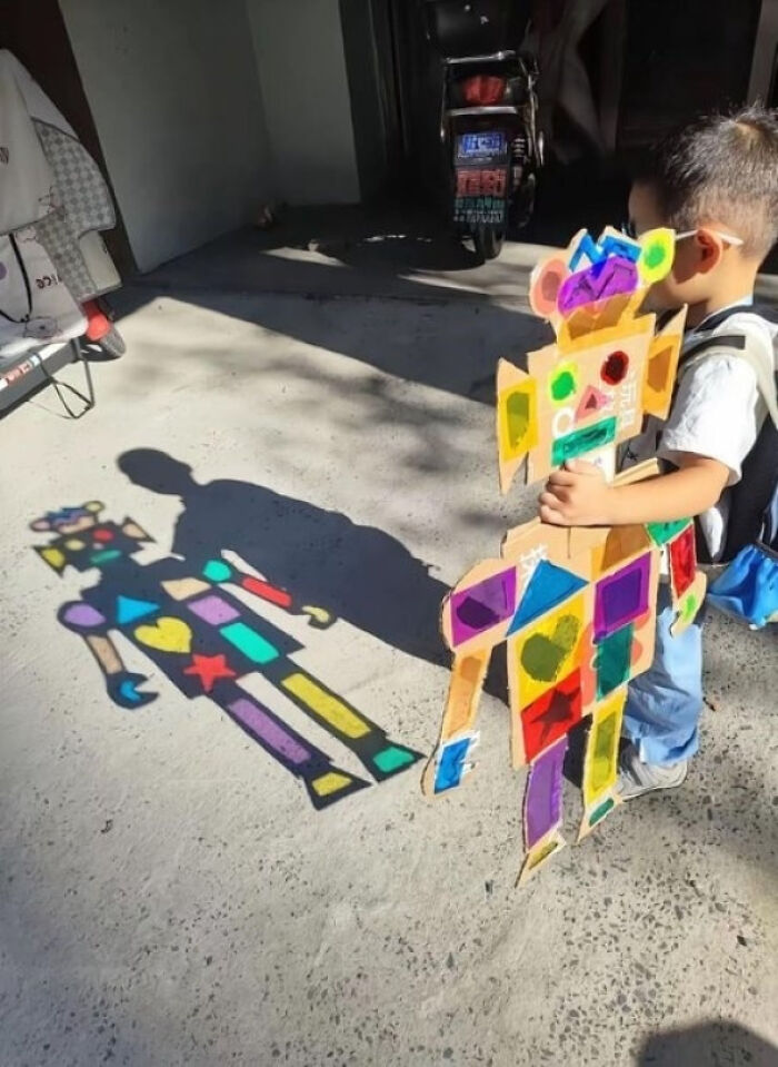 Child holding a colorful cardboard figure casting a creative shadow, exploring concepts of existence, reality, and the universe.