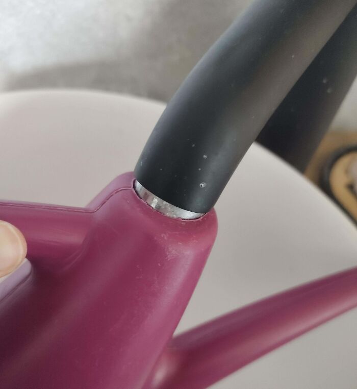 Close-up of a watering can spout perfectly aligned with the handle, showcasing flawless alignment in everyday objects.