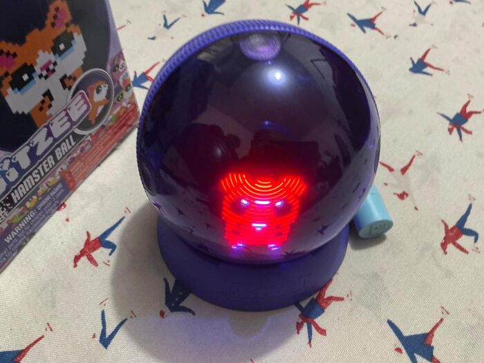 Purple spherical electronic toy displaying a red LED hamster face, featured in top Cyber Monday deals this year.