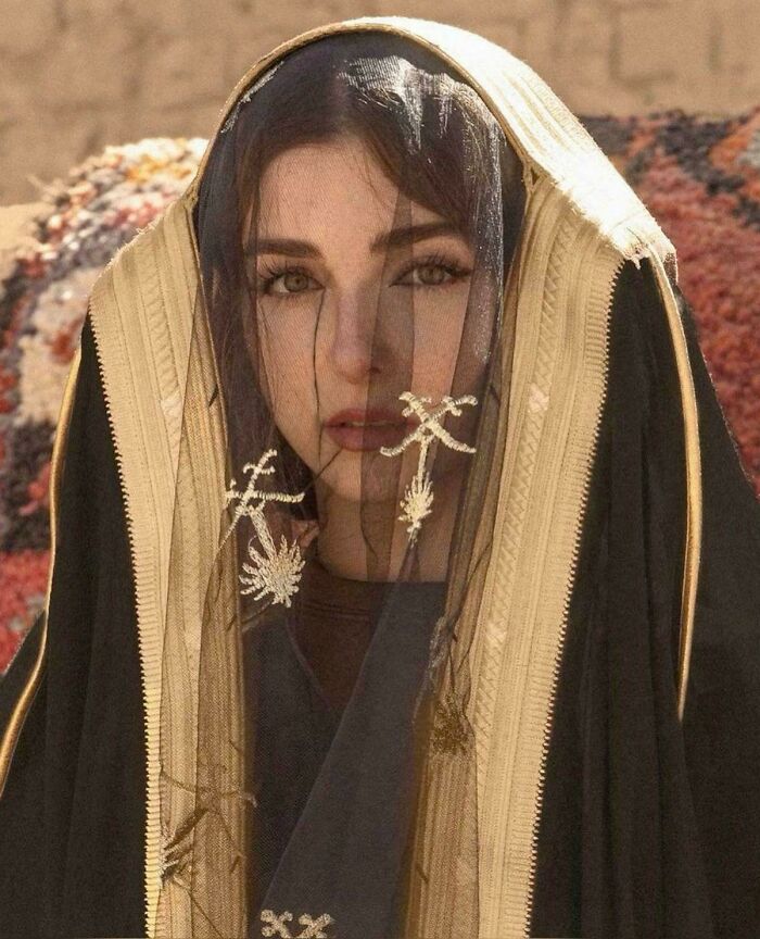 Portrait of a woman wearing a traditional embroidered black and beige veil, capturing human beauty and cultural diversity.