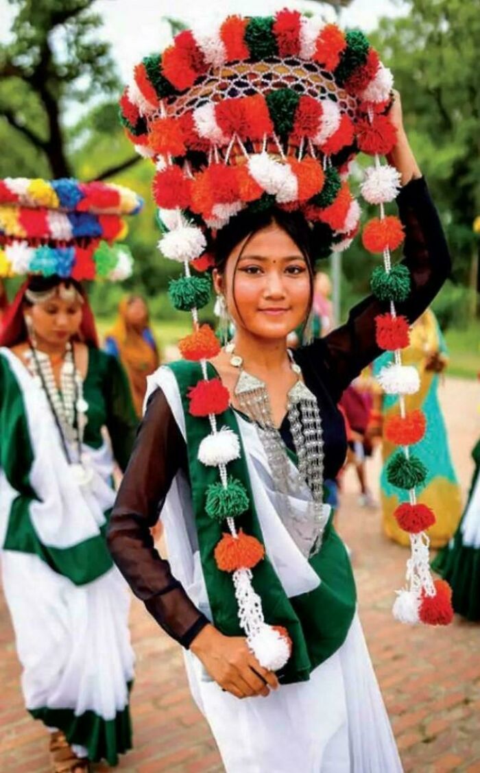 Young woman in traditional colorful attire and headpiece, showcasing the beauty and diversity of humans often overlooked.