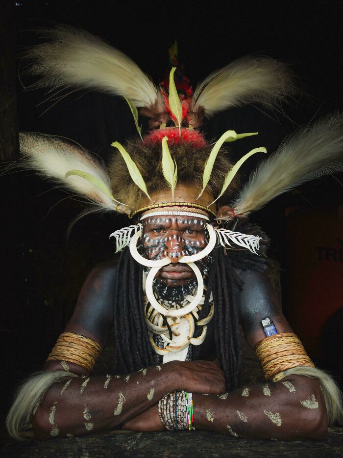 Tribal man with face paint and traditional feathered headdress, showcasing the beauty and diversity of humans.