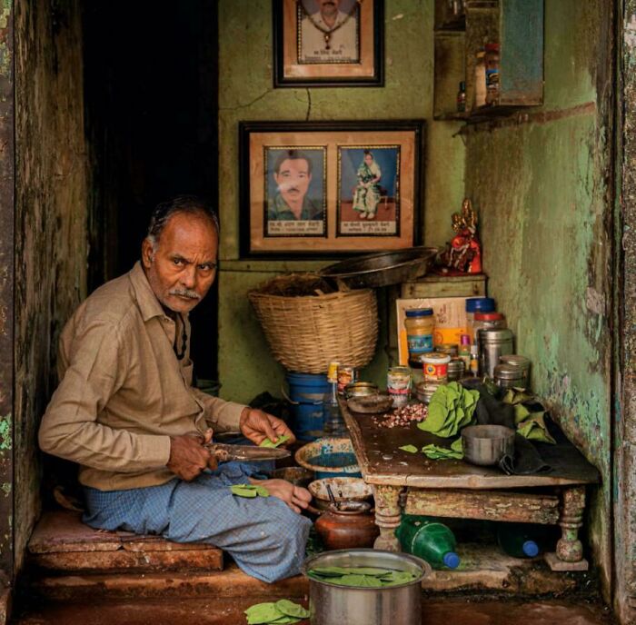 Elderly man preparing betel leaves in a rustic room, capturing the beauty strength and diversity of humans often overlooked.