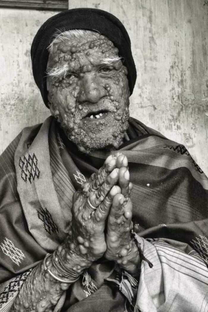 Elderly man with textured skin and hands in prayer, showcasing the beauty, strength, and diversity of humans.