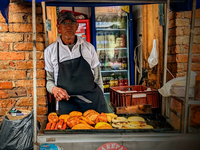 Middle-aged man in an apron cooking street food, showcasing the strength and diversity of humans often overlooked.