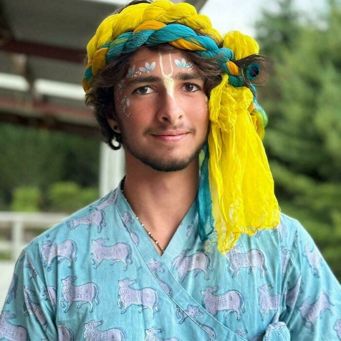 Portrait of a young man wearing a yellow and blue turban with face paint, showcasing human beauty, strength, and diversity.