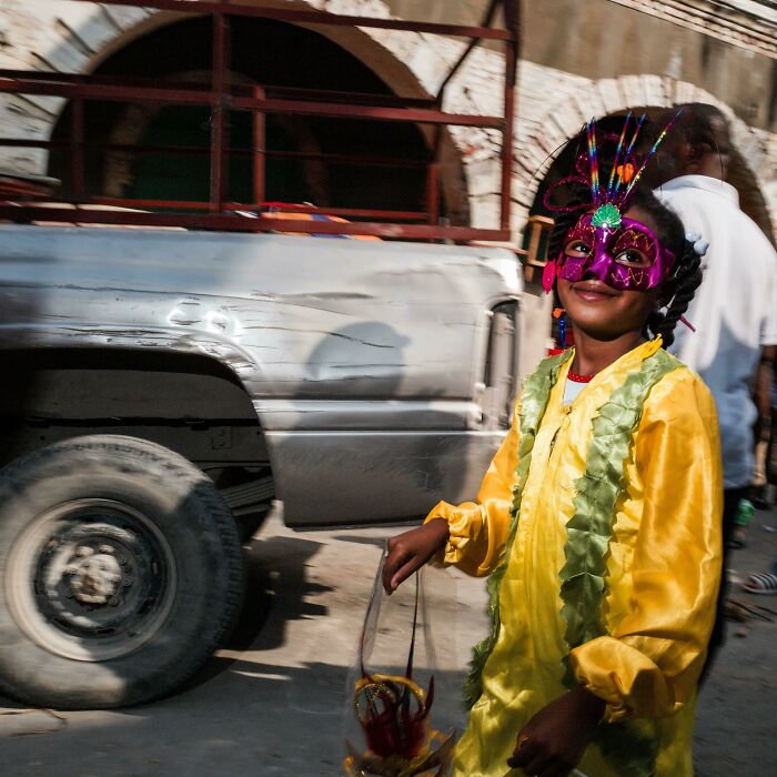 Young girl in vibrant costume and colorful mask, showcasing the beauty and diversity of humans often overlooked.