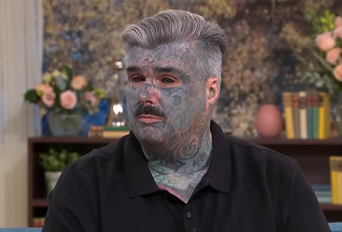Man with extensive facial tattoos discusses the dangerous process of eyeball tattooing in a television interview. Man with extensive facial tattoos discusses the dangerous process of eyeball tattooing in a television interview.