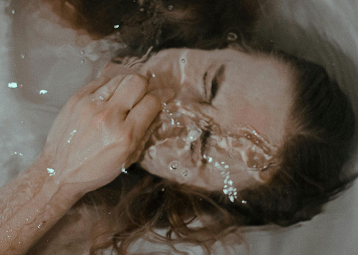 Person holding nose underwater with eyes closed, illustrating a visual metaphor for terrifying things found online.