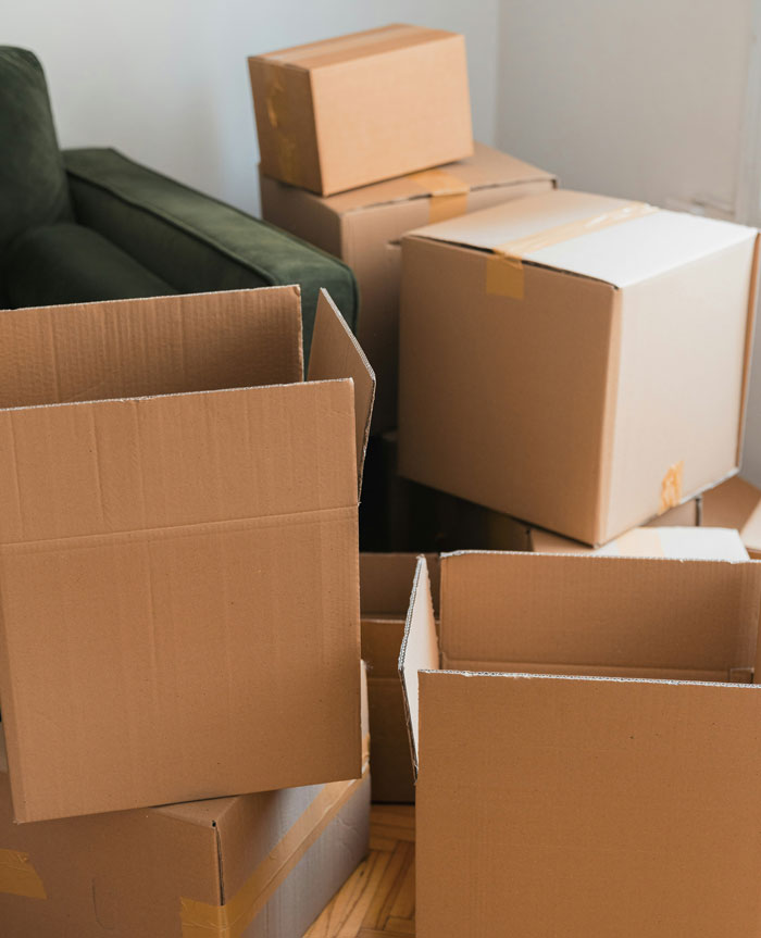 Stack of empty cardboard boxes near a green couch illustrating stories about people who don’t deserve nice things