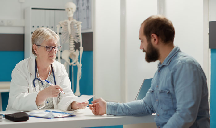 Doctor reviewing notes with a patient in a clinic, capturing funny patients’ comments that lighten hospital and clinic visits.