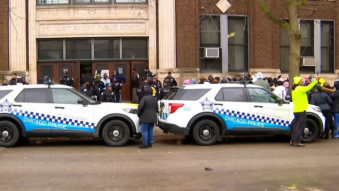 Chicago police outside Orvillet Bright Public School with crowd gathered after incident involving young school kids and pregnant woman.