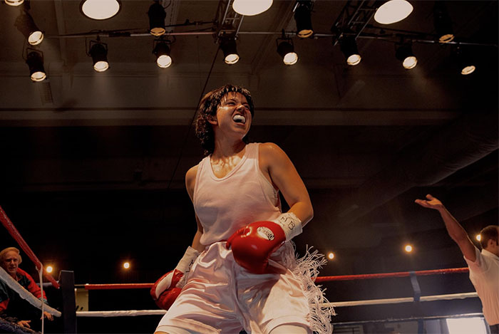 Boxing athlete celebrating victory inside ring under bright lights with leaked PR emails sparking damage control efforts.