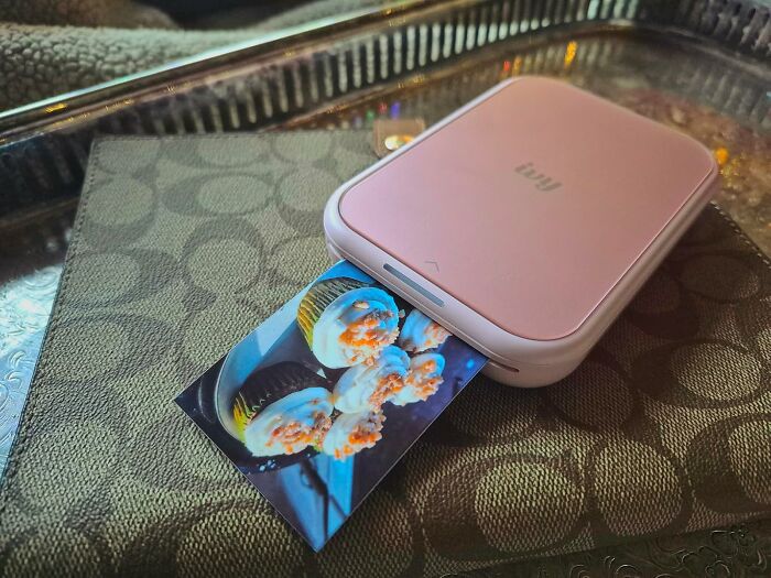 Portable photo printer producing a cupcake image, showcasing Black Friday week hot deals on tech gadgets and accessories.