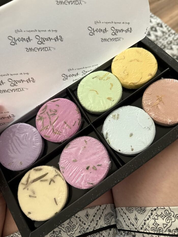 Colorful round bath bombs in a black box, perfect Black Friday stocking stuffers packed with natural herbs and scents.