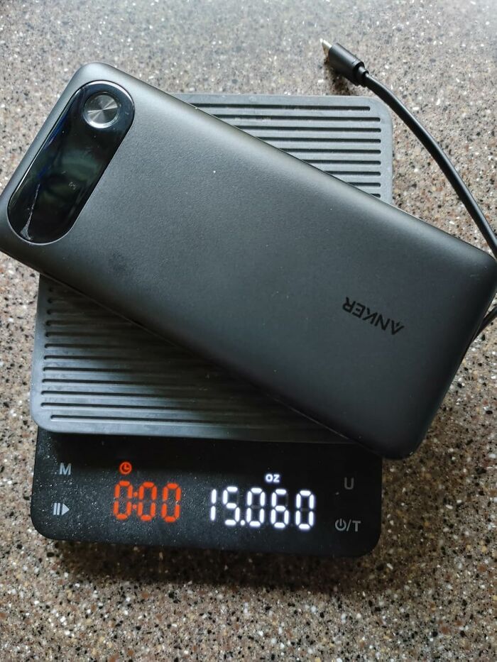 Black Friday deals on stocking stuffers featuring a portable Anker charger on a digital scale showing 15 ounces.