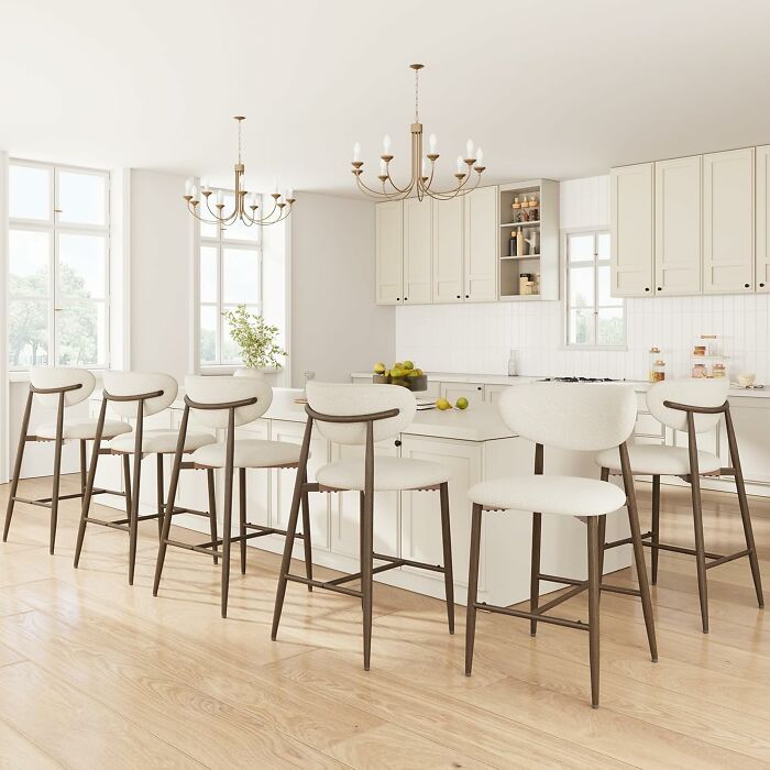 Modern kitchen interior with white cabinets and bar stools highlighting Black Friday kitchen deals concept.