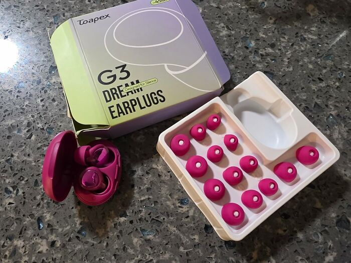 Purple wireless earbuds with multiple silicone ear tips displayed beside packaging for 11.11 deals on tech accessories.