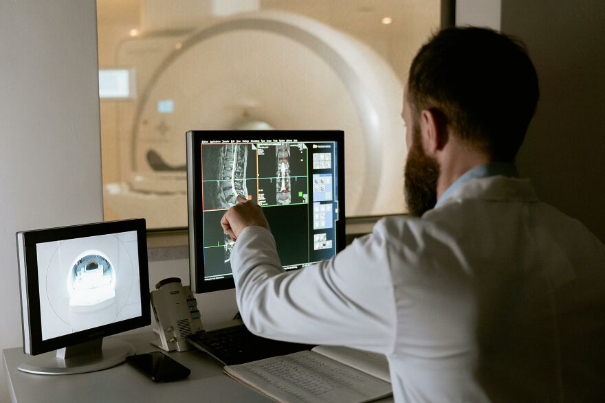 Doctor examining MRI scans of a broken bone, related to the broken bone theory in a medical setting.
