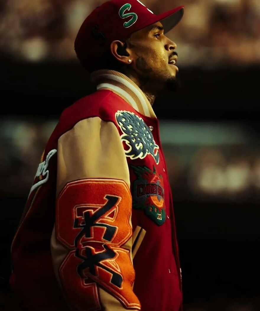 Chris Brown in a red varsity jacket and cap seen in profile, featured in unexpected members-only fan pages.