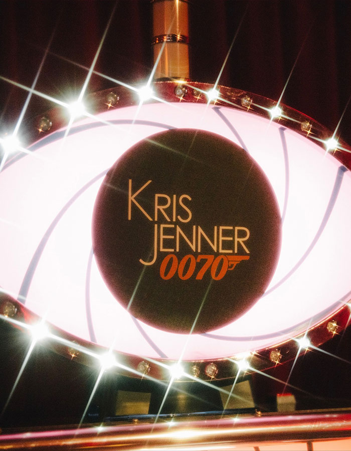 Illuminated Kris Jenner 0070 sign with sparkling lights at her 70th birthday bash guest list event.