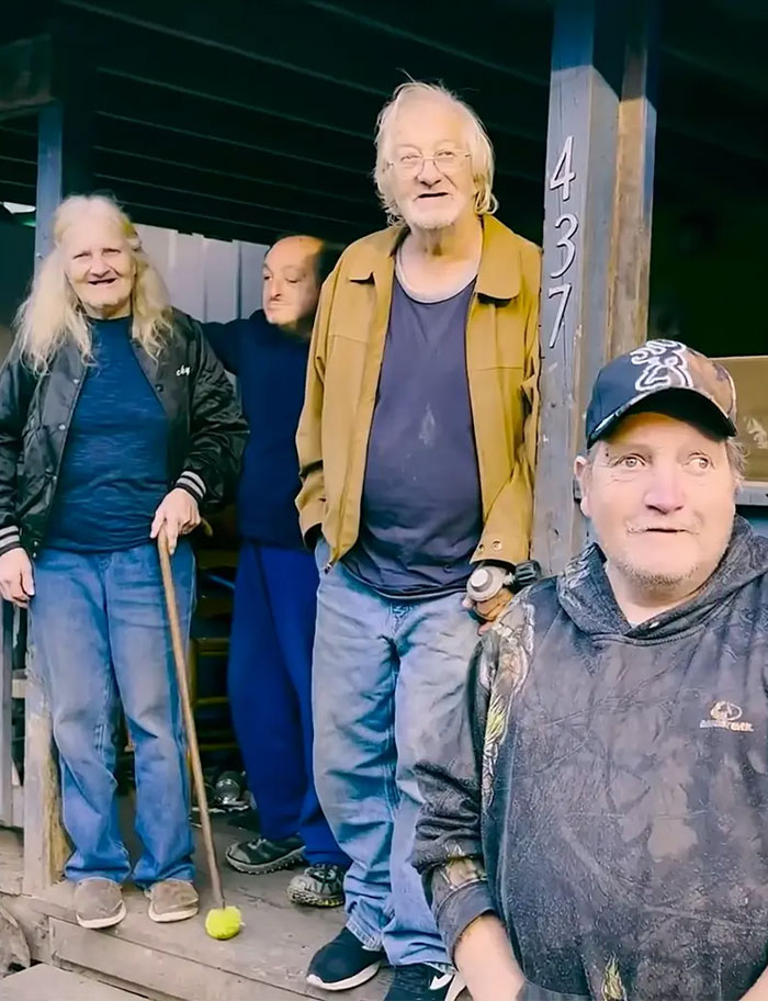 Group of people standing outside a rustic home, representing America's most inbred family featured in viral internet reaction.