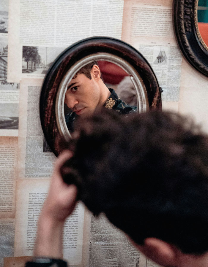 Man with dark hair looking at his reflection in a vintage mirror, representing red flags that could mean someone is a narcissist. Man with dark hair looking at his reflection in a vintage mirror, representing red flags that could mean someone is a narcissist.