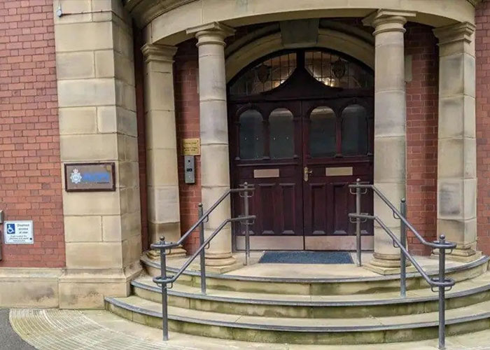 Entrance of police station building with columns and steps, related to trainee police officer lifetime ban case. Entrance of police station building with columns and steps, related to trainee police officer lifetime ban case.