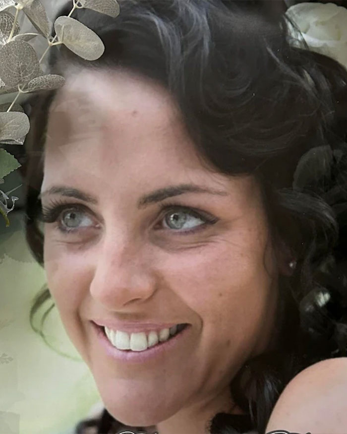 Close-up of a smiling woman with curled dark hair highlighting the risks faced by women after a BBL procedure.